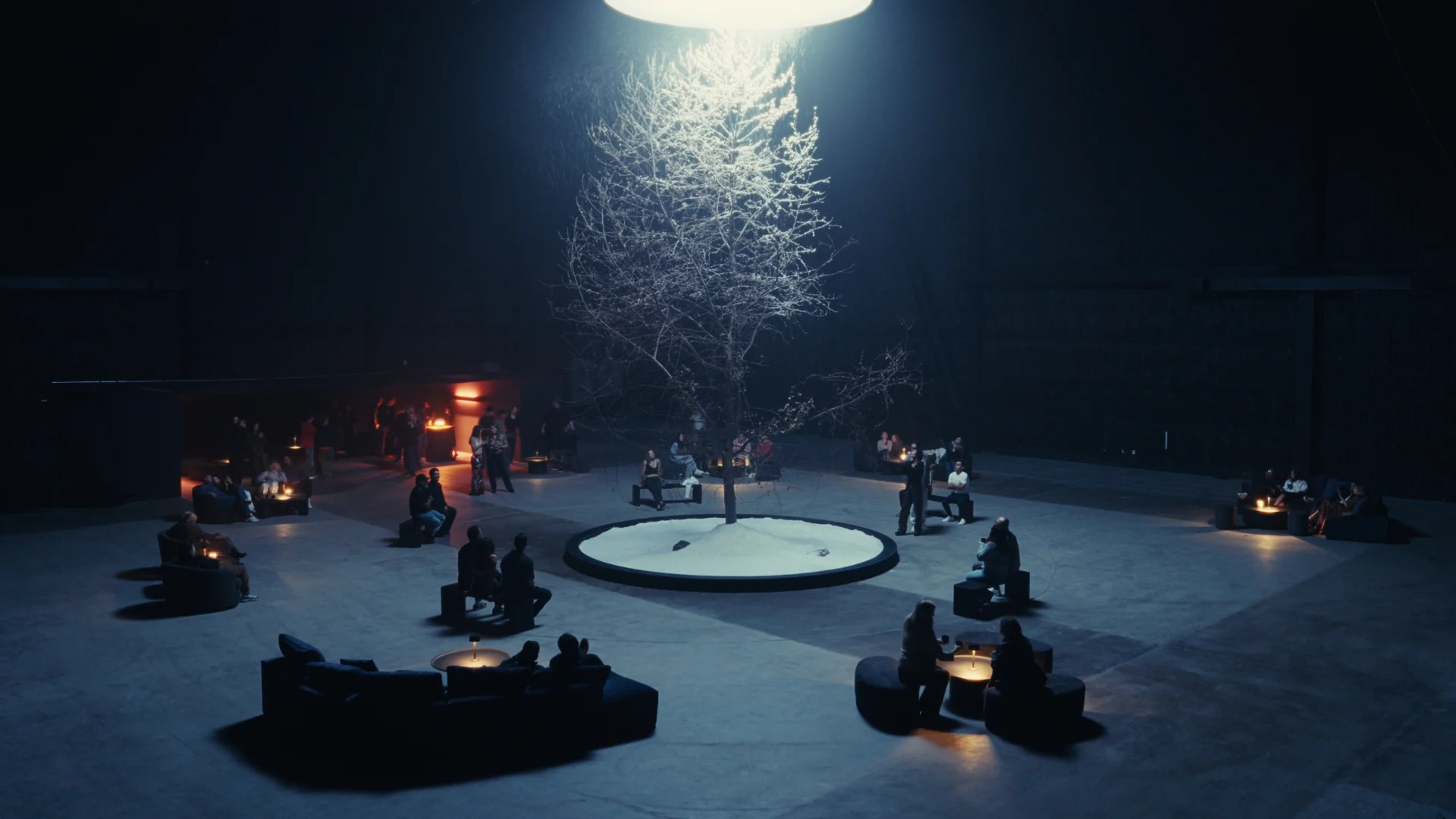 The performance room with the lit tree and seating around the water