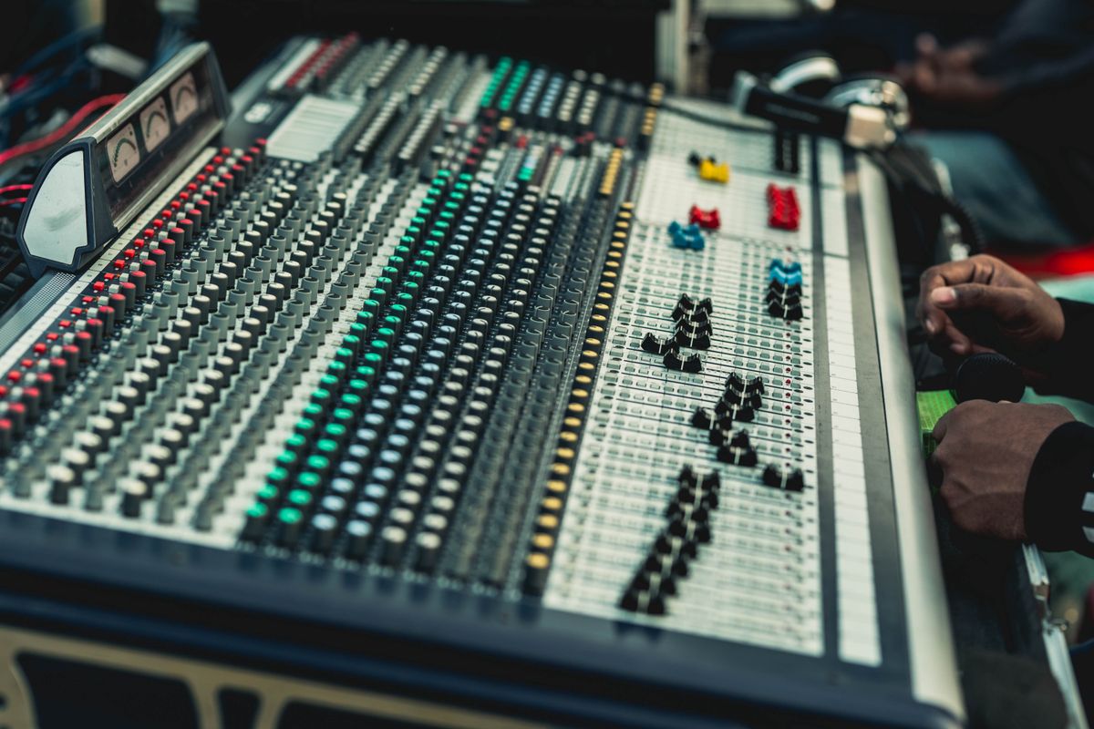 Sound engineer adjusting a professional audio mixing console