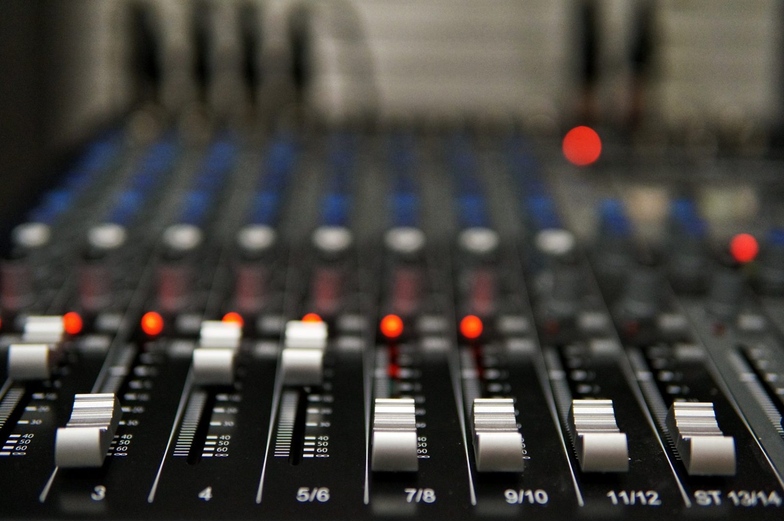 Close-up of audio console faders being mixed during a worship service